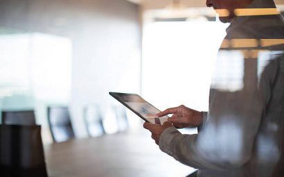 Homme qui regarde une tablette dans une salle de réunion