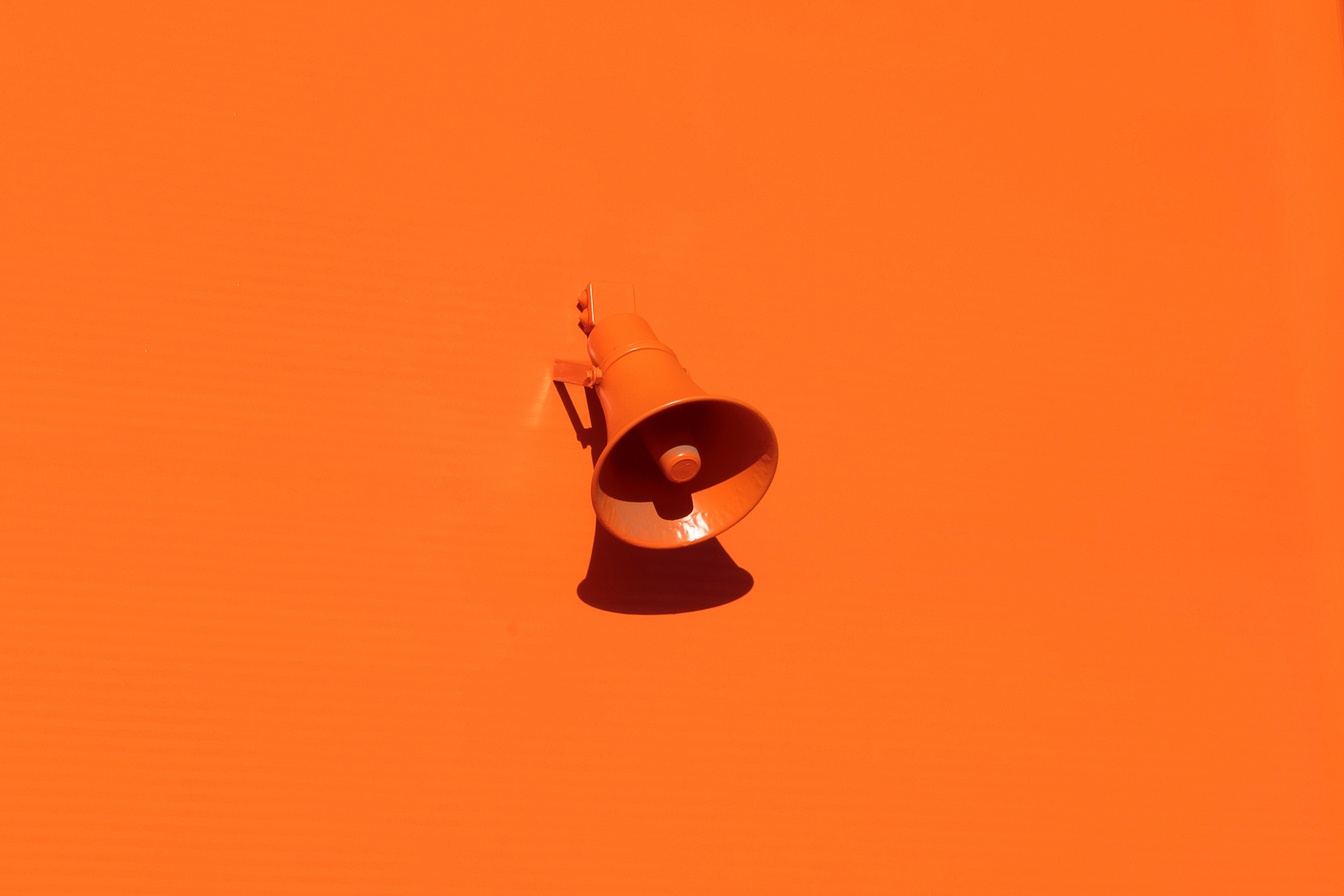 une megaphone orange sur un mur orange