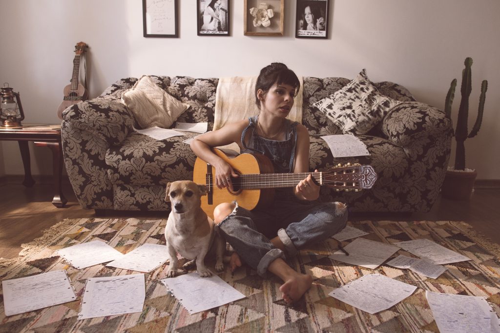 Un femme faisant de la guitare avec son chien